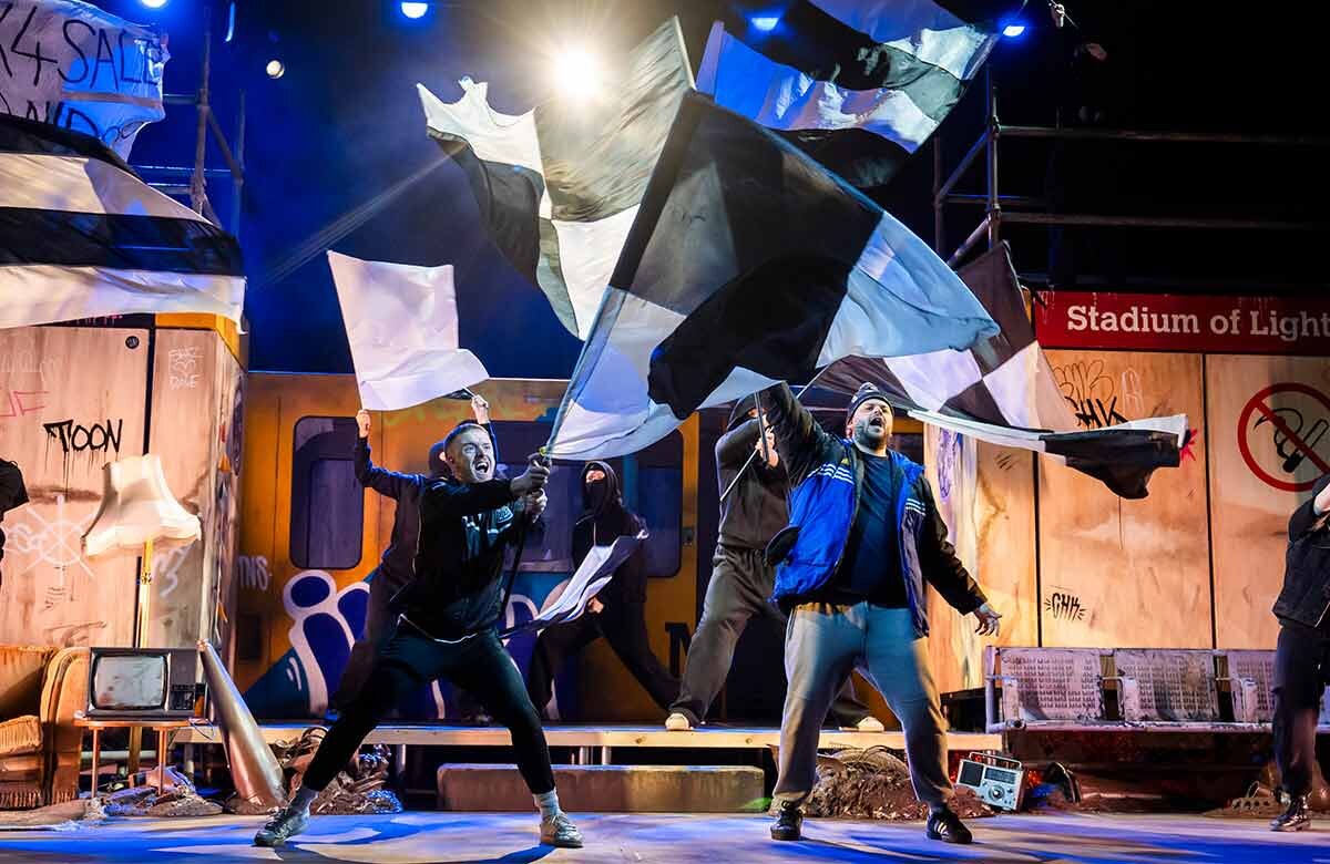 Gerry & Sewell company waving WOR flags on stage at the Aldwych Theatre